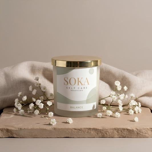 BALANCE SOKA self-care candle on a stone surface with baby's breath flowers and neutral background