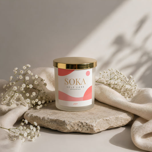 JOY SOKA self-care candle on a stone surface and neutral background