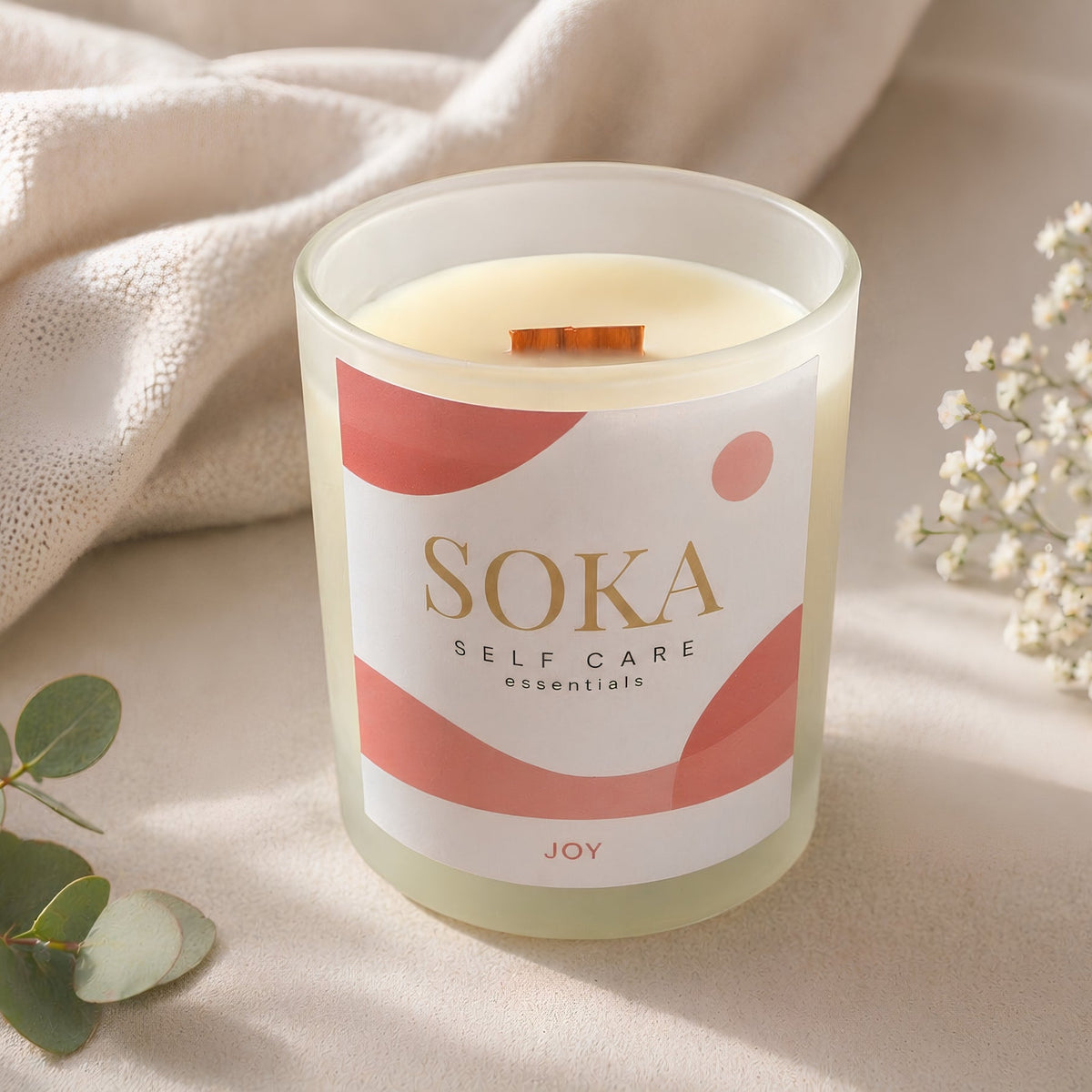 JOY SOKA self-care candle on a linen surface and neutral background